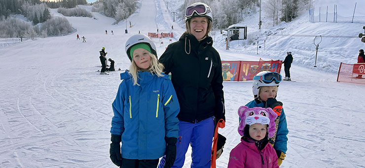 Fia med sina två döttrar. De har står i en slalombacke och har skidor på sig. 
