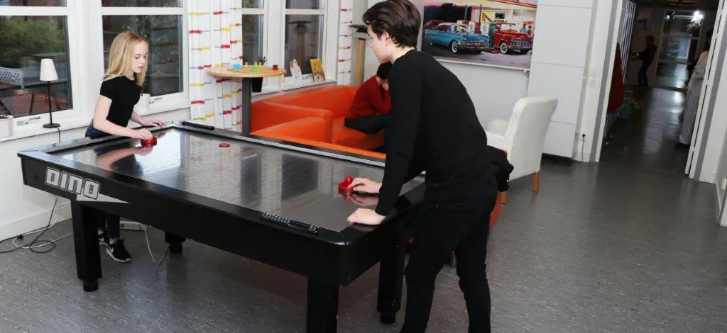 Två barn spelar airhockey.