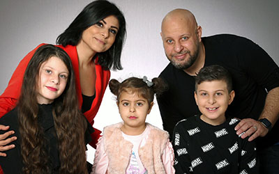 Heba och Essam med sina tre barn. En  porträttbild där hela familjen står uppställda och tittar in i kameran. 