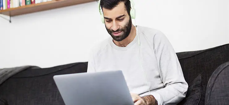 Man tittar in i sin laptop.