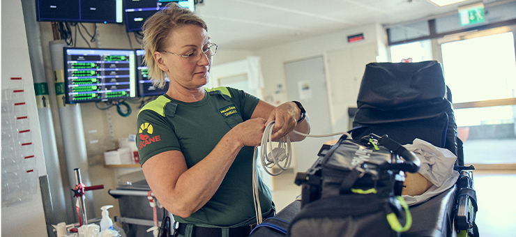 Ambulanssjuksköterska i gröna arbetskläder.
