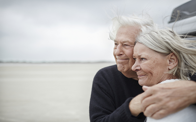 Två äldre personer som håller om varandra och ser glada ut.