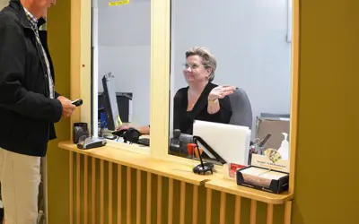 En besökare får vägvisning av personalen i receptionen.